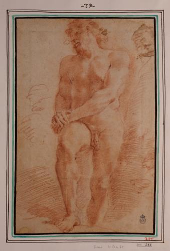 Estudio de modelo masculino desnudo de pie con la pierna derecha apoyada y las manos sobre el muslo