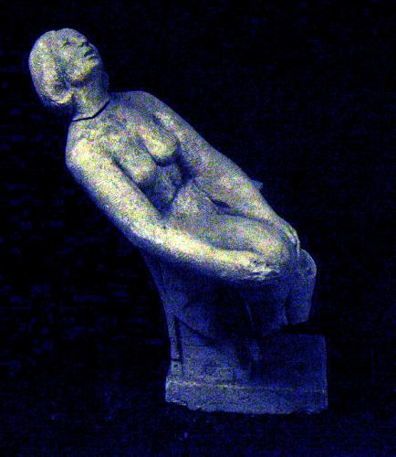 Mujer recostada sobre un sillón cogiéndose una pierna