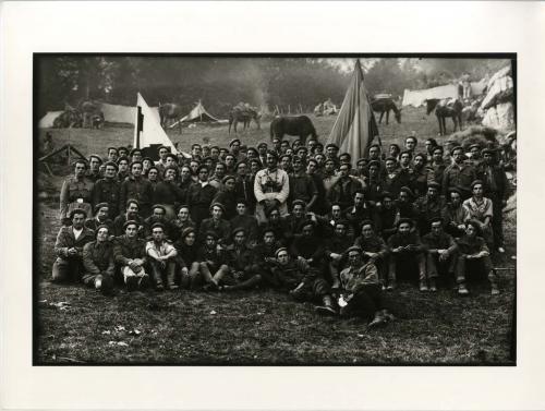 Retrato grupal de requetés con banderas en campamento alavés.